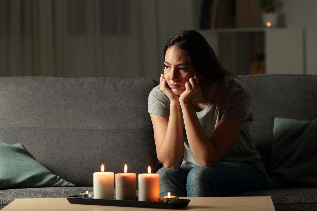 donna in casa senza corrente con candele accese